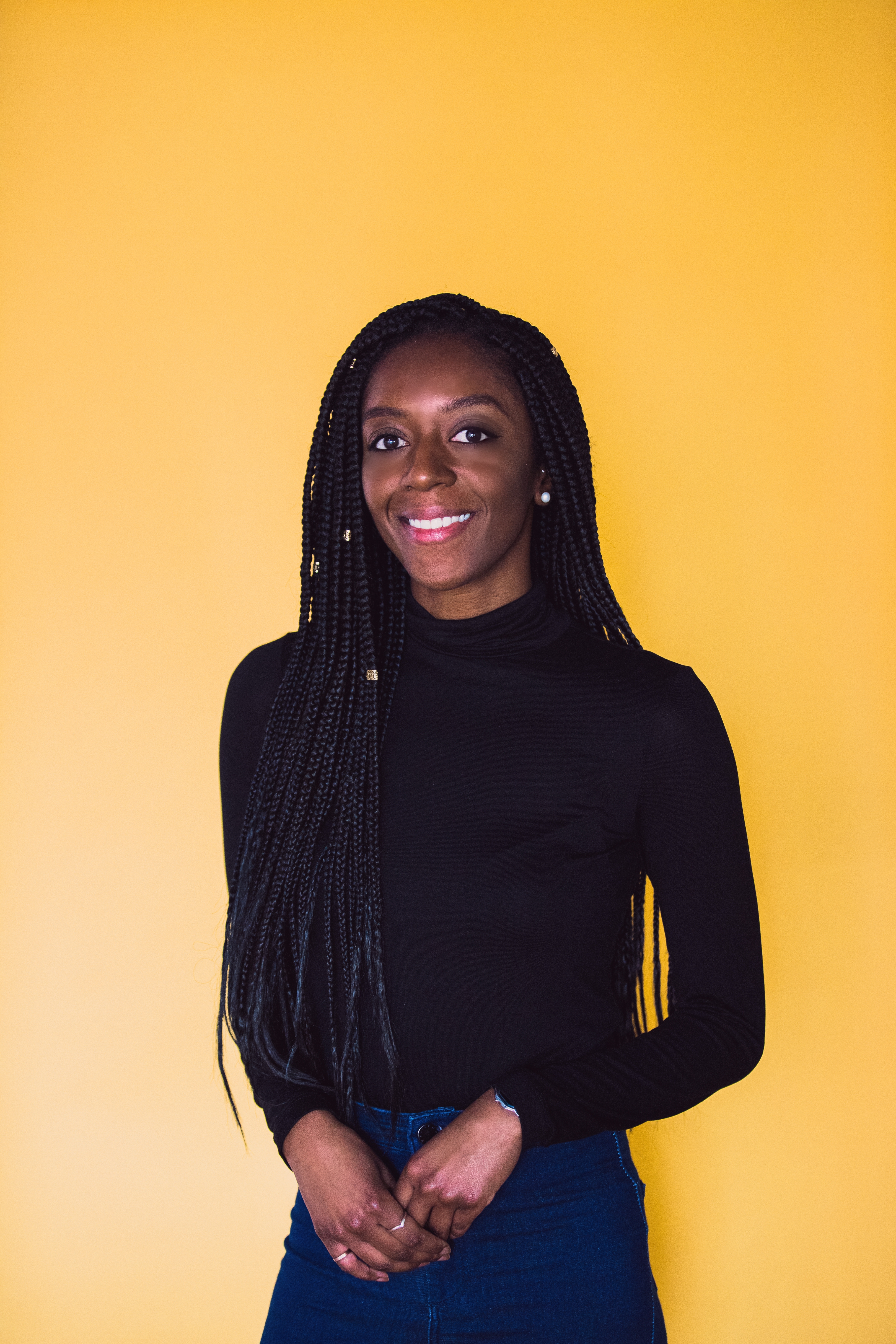 Afua Deborah standing in front of yellow background
